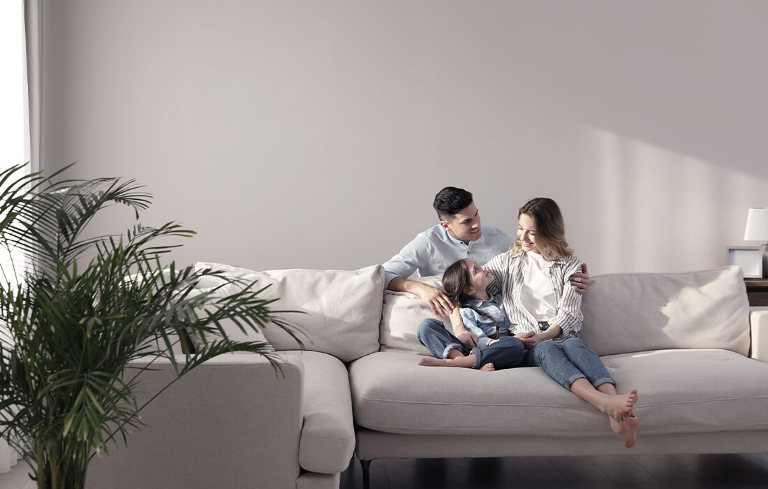Young Family Sitting On Couch